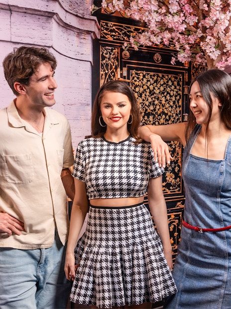 Couple posing with Selena Gomez wax figure at Madame Tussauds, New York.