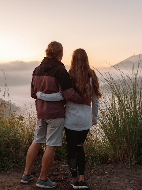 Couple admiring Mount Batur during sunrise trek in Bali.