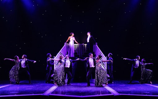 Stage performance of "Some Like it Hot" with dancers in formal attire.