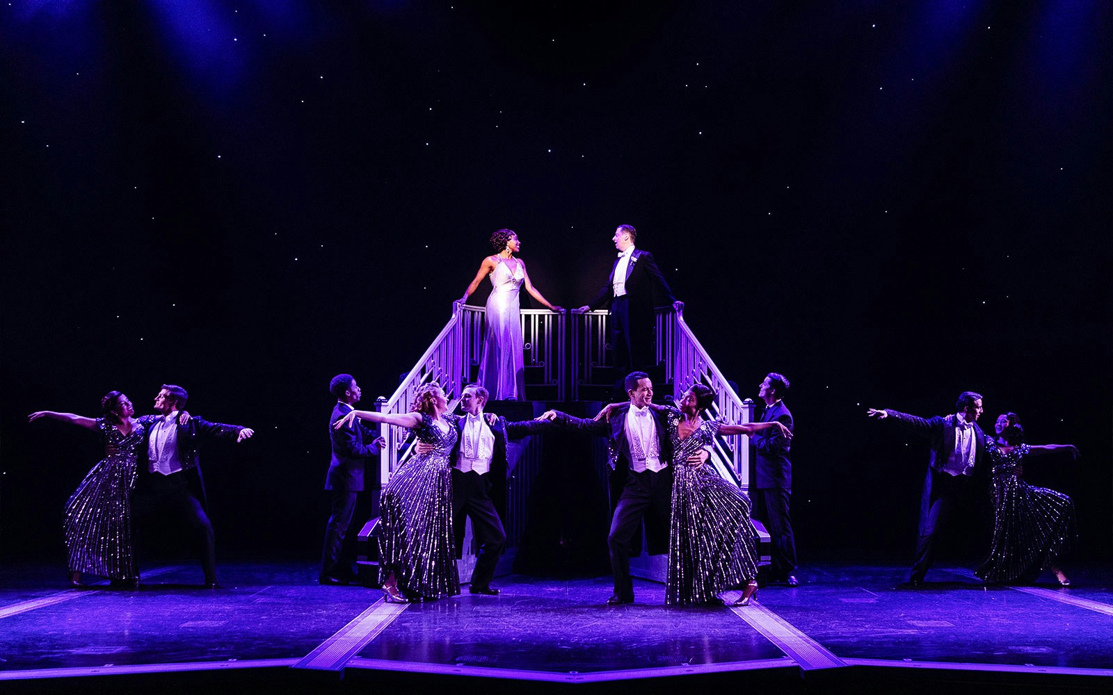 Stage performance of "Some Like it Hot" with dancers in formal attire.
