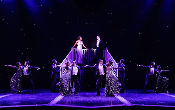 Stage performance of "Some Like it Hot" with dancers in formal attire.