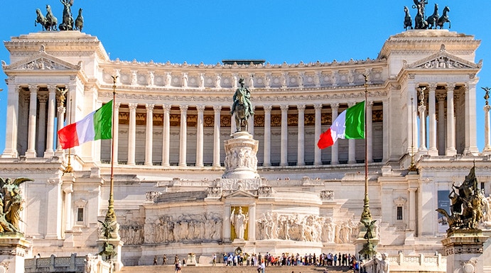 Altare della Patria in Rome with Italian flags and tourists exploring the monument.