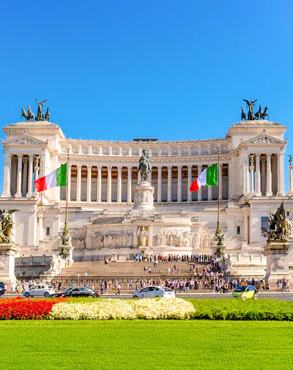 Altare della Patria in Rome with Italian flags and tourists exploring the monument.