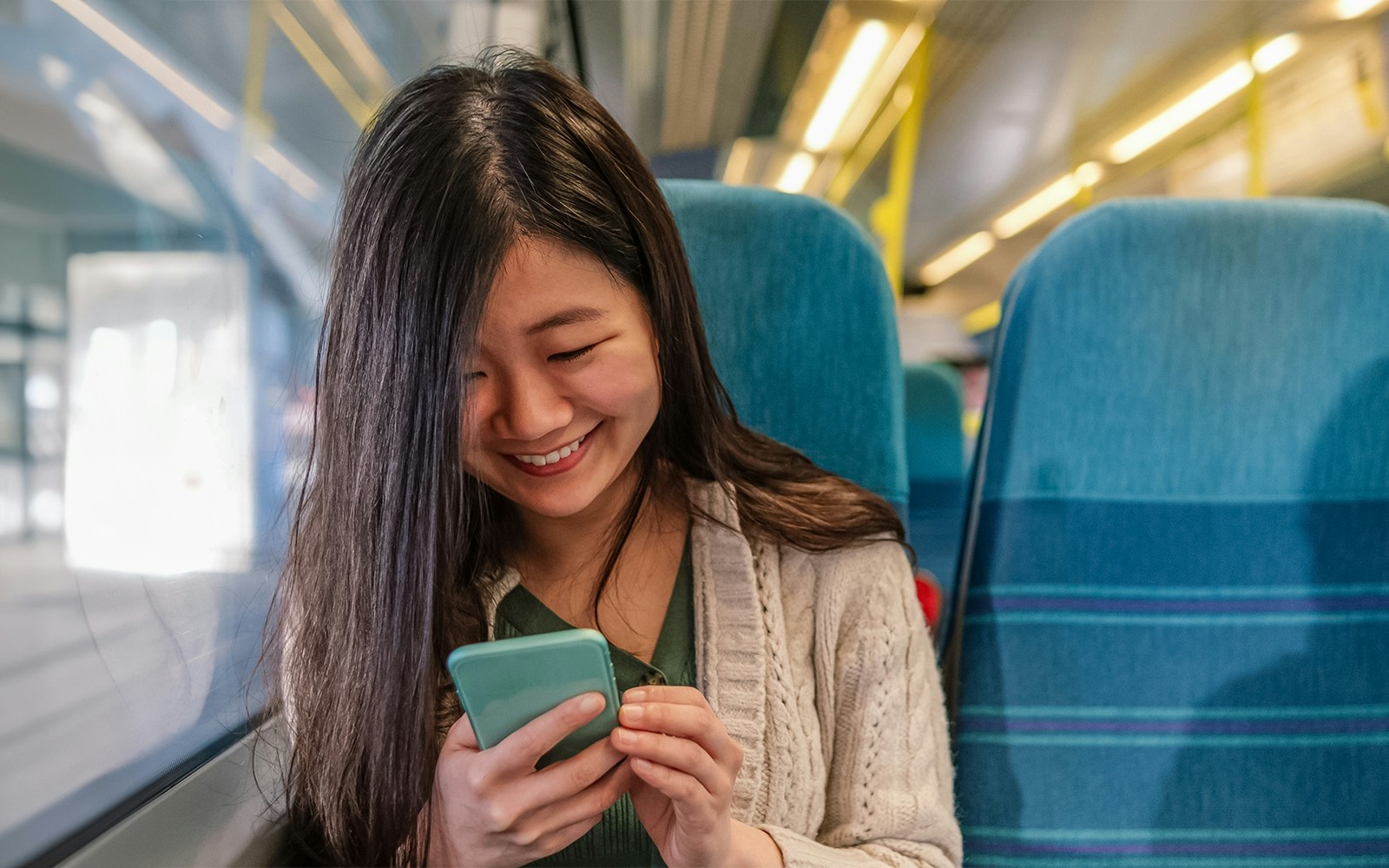 Woman using WiFi on Shinkansen bullet train in Japan.