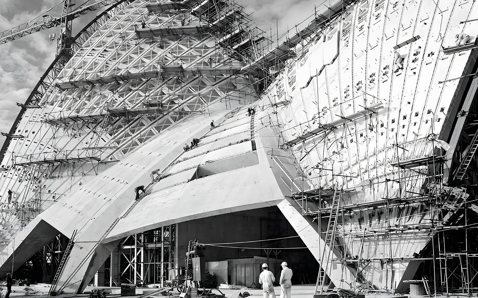 Sydney Opera House under construction, showcasing sails and scaffolding.