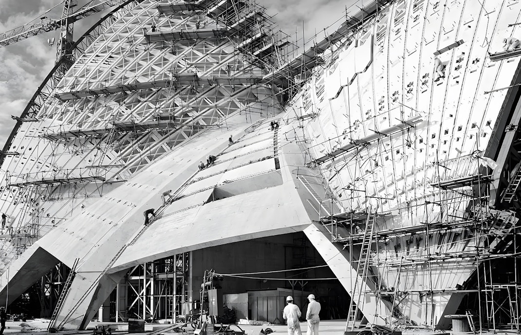 Sydney Opera House under construction, showcasing sails and scaffolding.