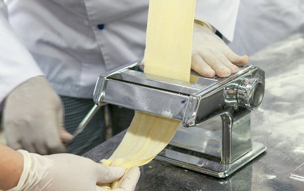 Making pasta with a machine during a cooking class near the Colosseum.