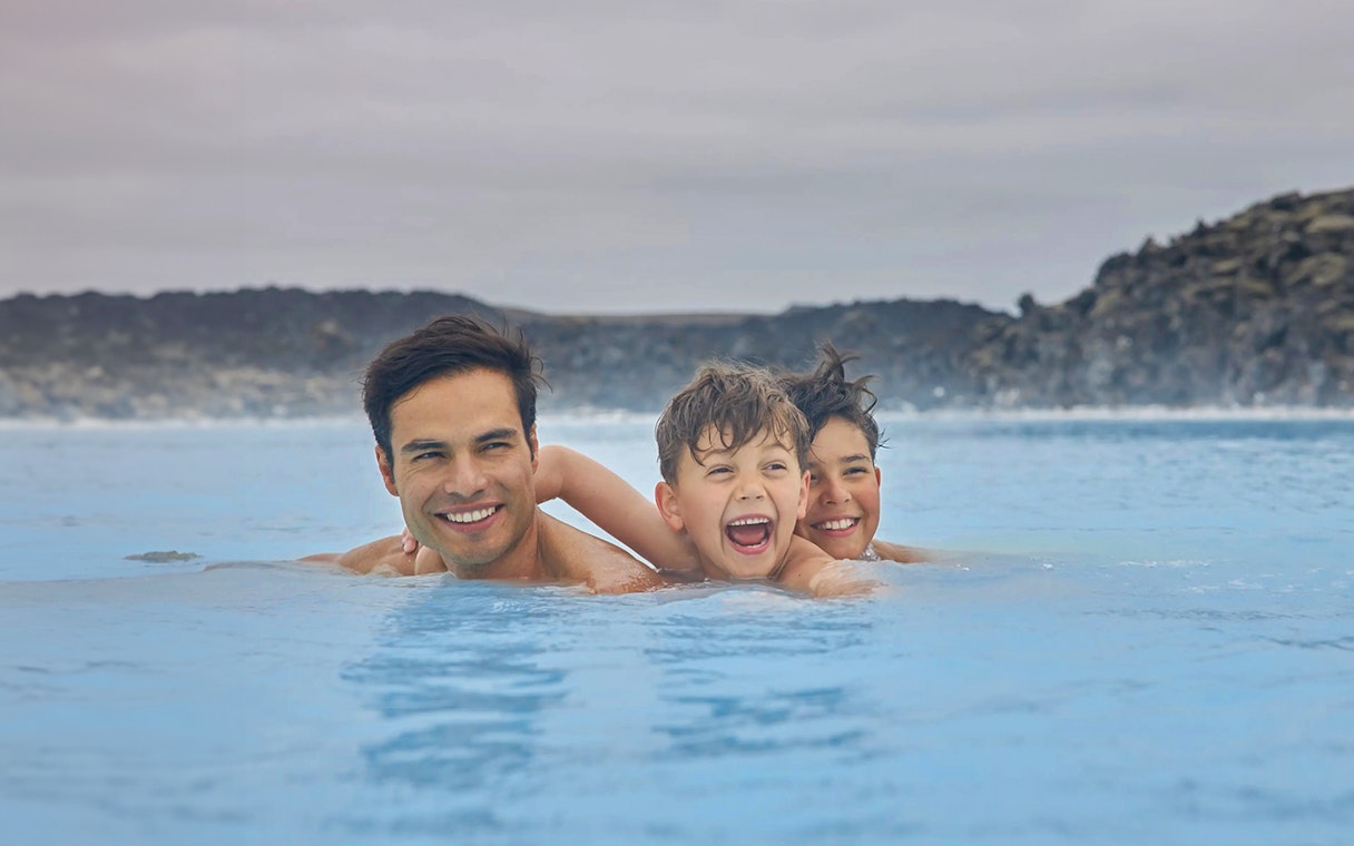 Family enjoying the geothermal waters of Blue Lagoon, Iceland.