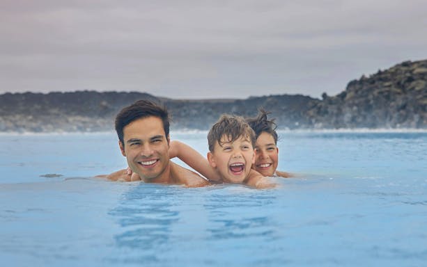 Family enjoying the geothermal waters of Blue Lagoon, Iceland.