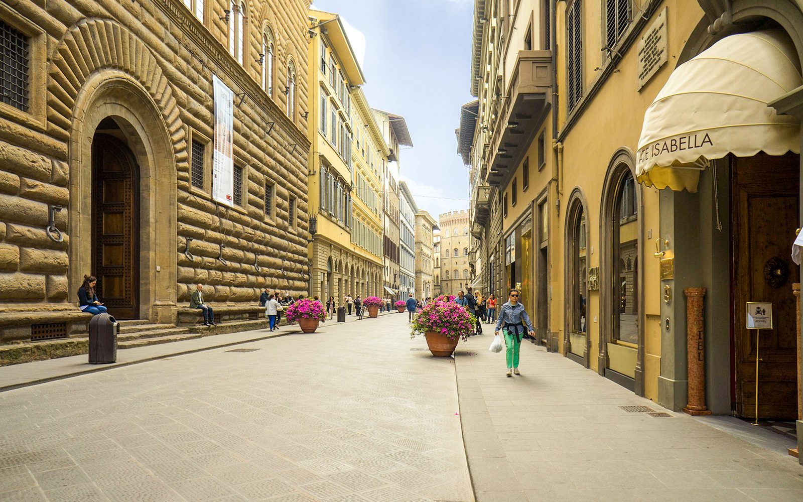 Street view near Palazzo Strozzi, Florence, Italy, with people walking and historic architecture.