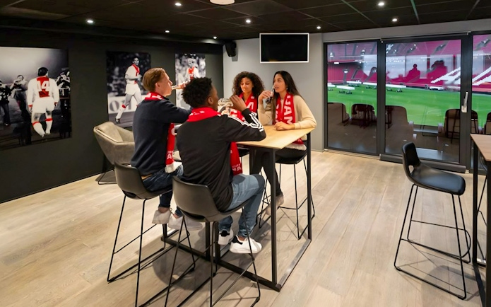 Visitors enjoying drinks and a view of the field during a VIP tour at Johan Cruijff ArenA, Amsterdam.