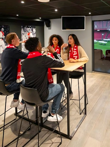 Visitors enjoying drinks and a view of the field during a VIP tour at Johan Cruijff ArenA, Amsterdam.