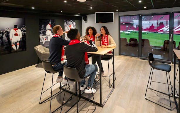Visitors enjoying drinks and a view of the field during a VIP tour at Johan Cruijff ArenA, Amsterdam.