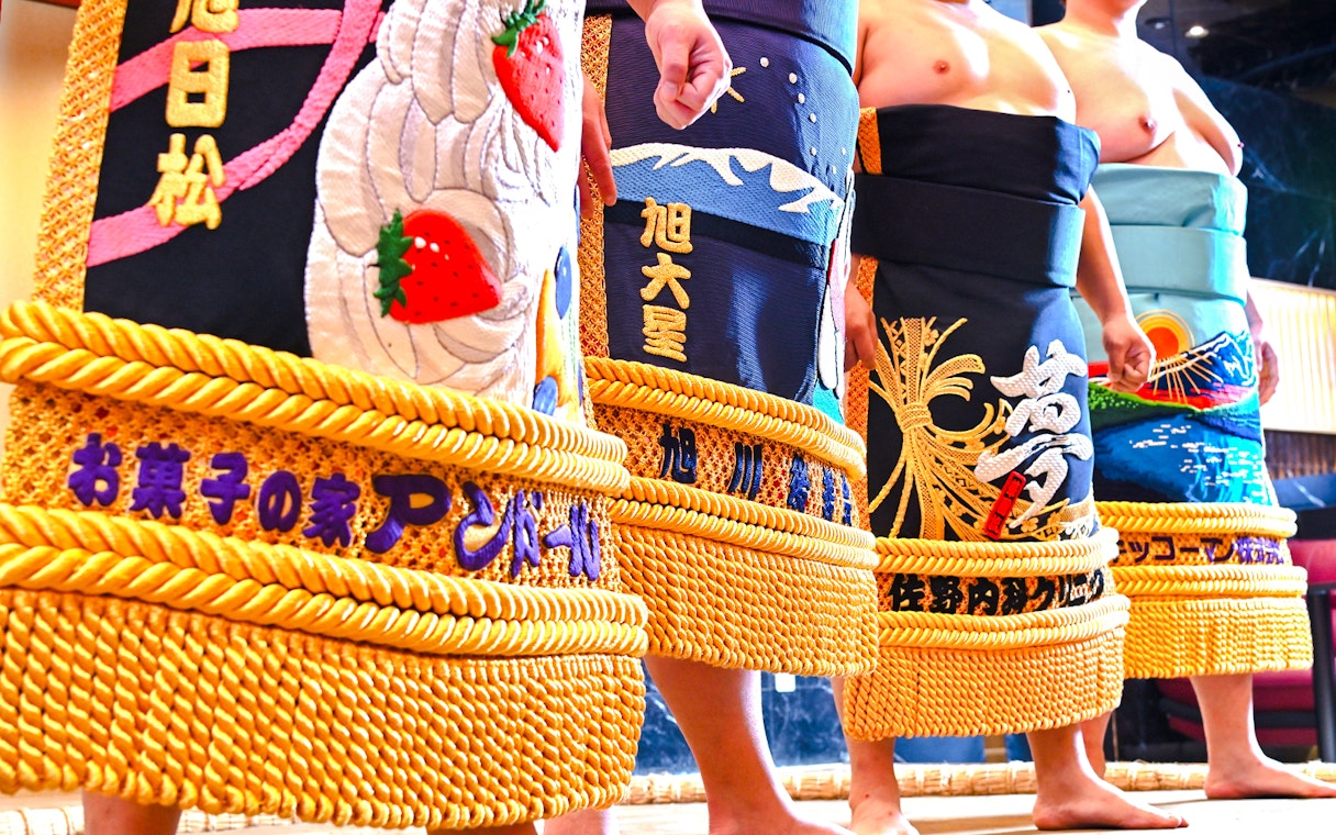 Sumo wrestlers in traditional attire at Asakusa Sumo Club, Tokyo.