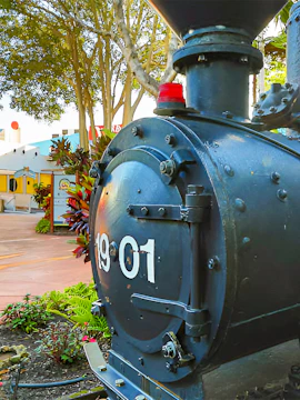 Historic train engine at The Ginger Factory, surrounded by lush greenery.