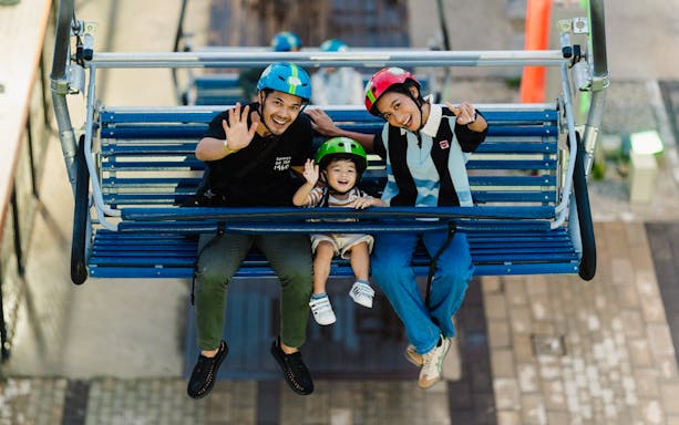 Skyline Luge Kuala Lumpur chair lift with families enjoying city views.