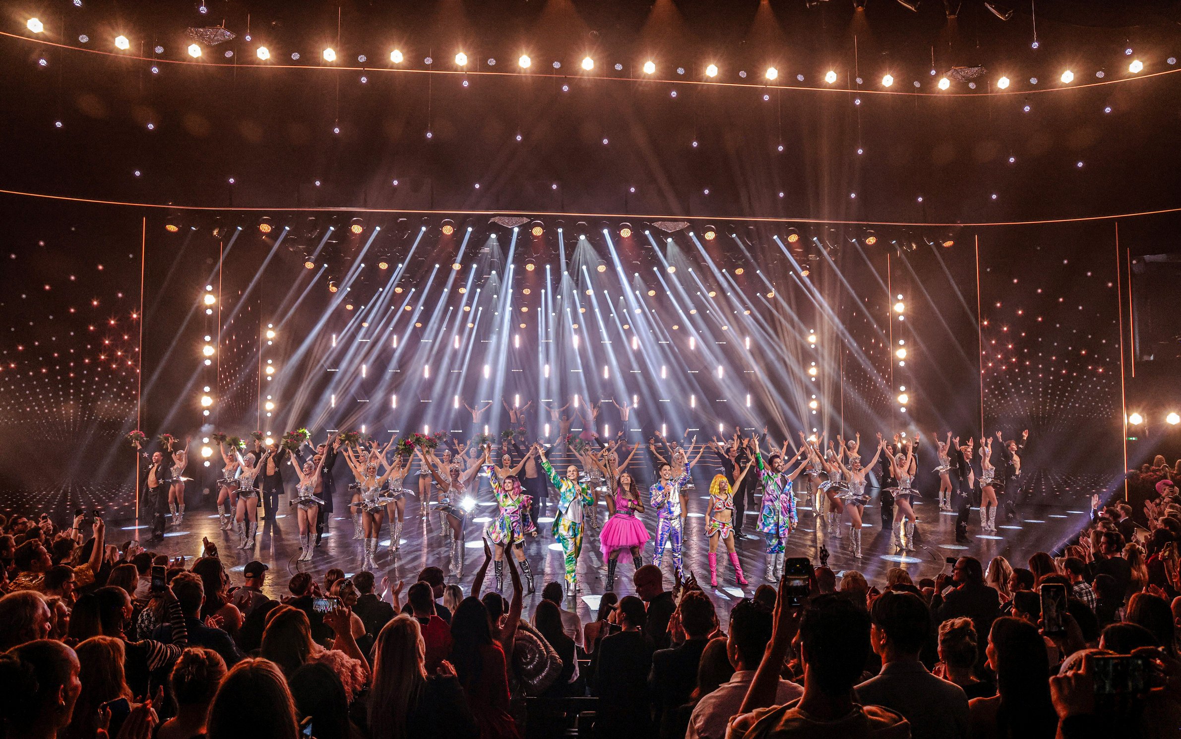 Performers on stage at Friedrichstadt Palast, Berlin, with vibrant costumes and lighting effects.