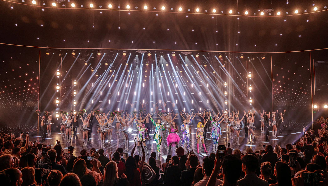 Performers on stage at Friedrichstadt Palast, Berlin, with vibrant costumes and lighting effects.