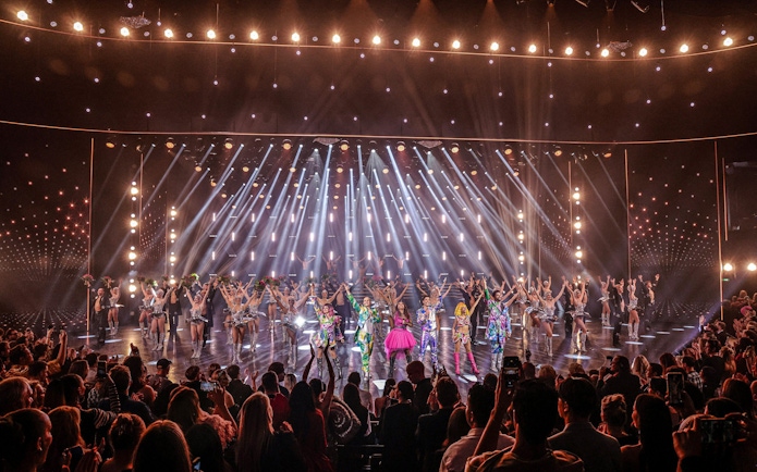 Performers on stage at Friedrichstadt Palast, Berlin, with vibrant costumes and lighting effects.