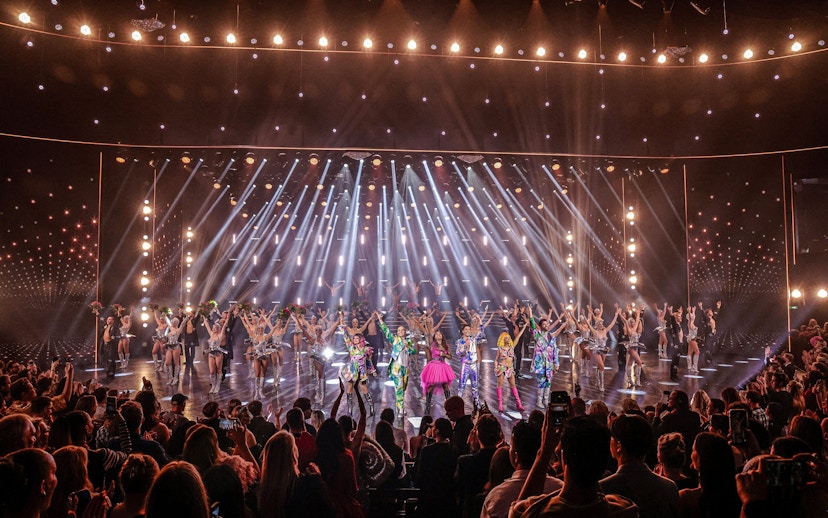 Performers on stage at Friedrichstadt Palast, Berlin, with vibrant costumes and lighting effects.