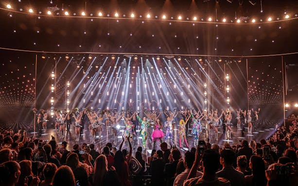 Performers on stage at Friedrichstadt Palast, Berlin, with vibrant costumes and lighting effects.