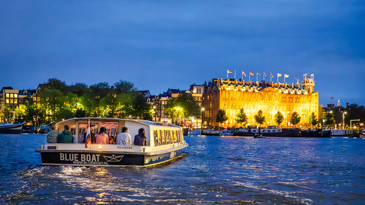 Winter evening canal cruise in Amsterdam with illuminated buildings.