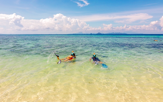 Snorkelers exploring clear waters near Bamboo Island, Thailand.