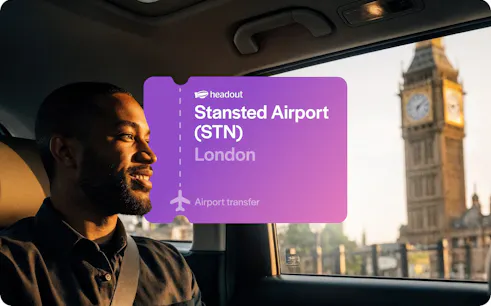 Man in car with Big Ben visible through window, London airport transfer.