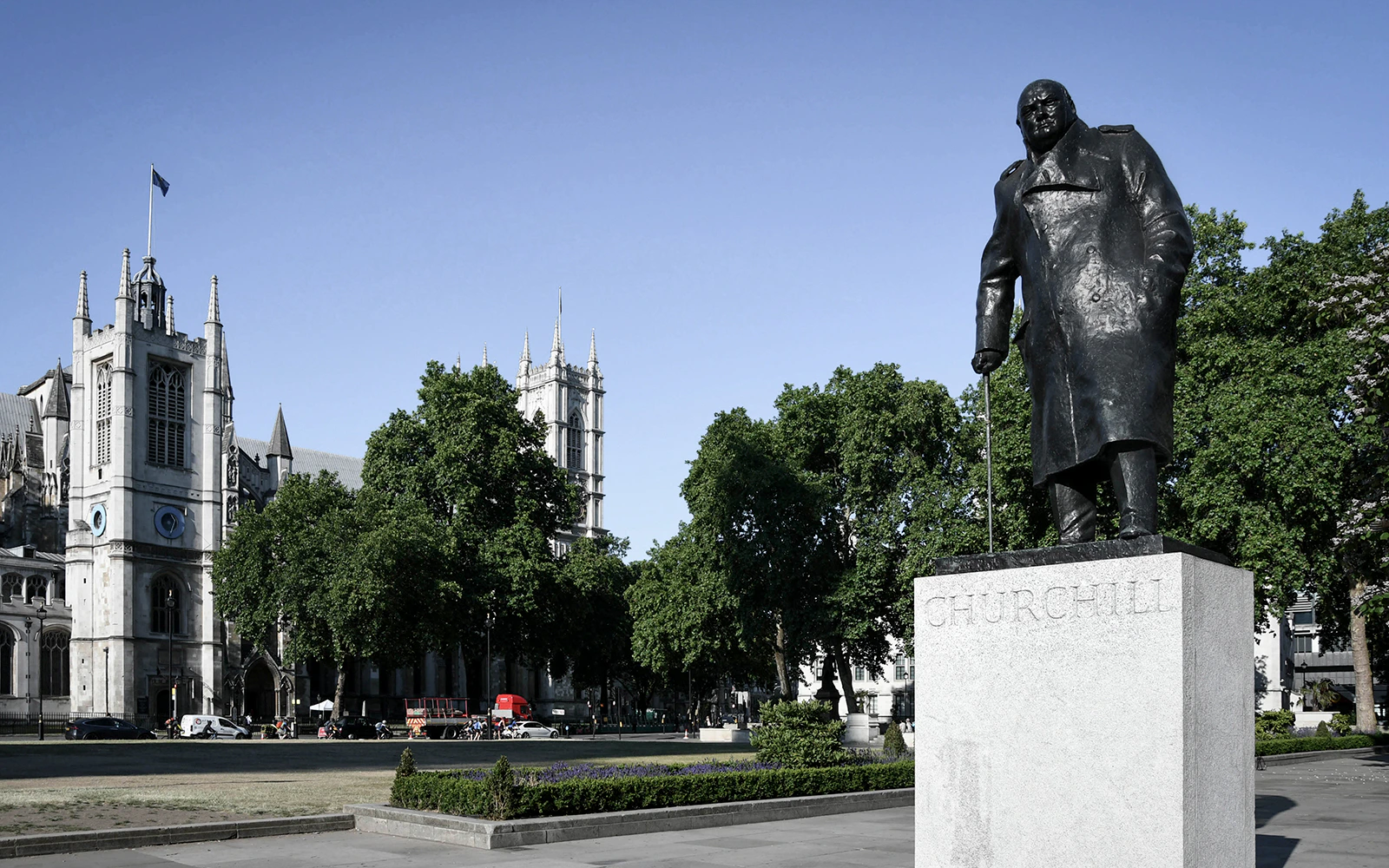 Statue of Churchill near Westminster Abbey on a sunny day.