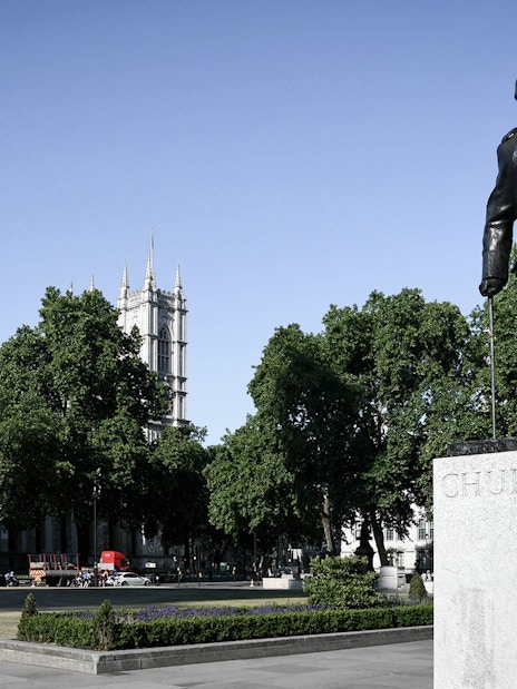 Statue of Churchill near Westminster Abbey on a sunny day.