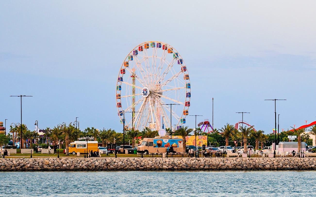 Ferris wheel and food trucks at Lusail Winter Wonderland, Qatar.