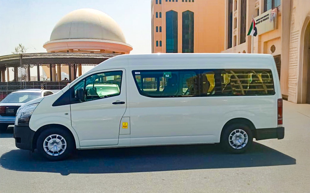 White transfer van at Dubai Safari Park entrance.