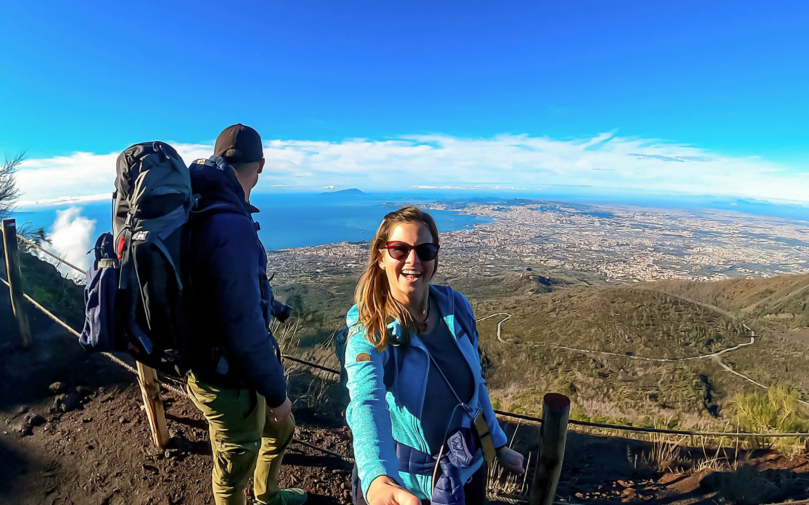 Hikers enjoying the scenic view from Mount Vesuvius overlooking the Bay of Naples.