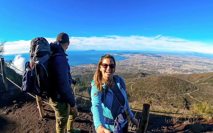 Hikers enjoying the scenic view from Mount Vesuvius overlooking the Bay of Naples.