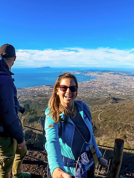 Hikers enjoying the scenic view from Mount Vesuvius overlooking the Bay of Naples.