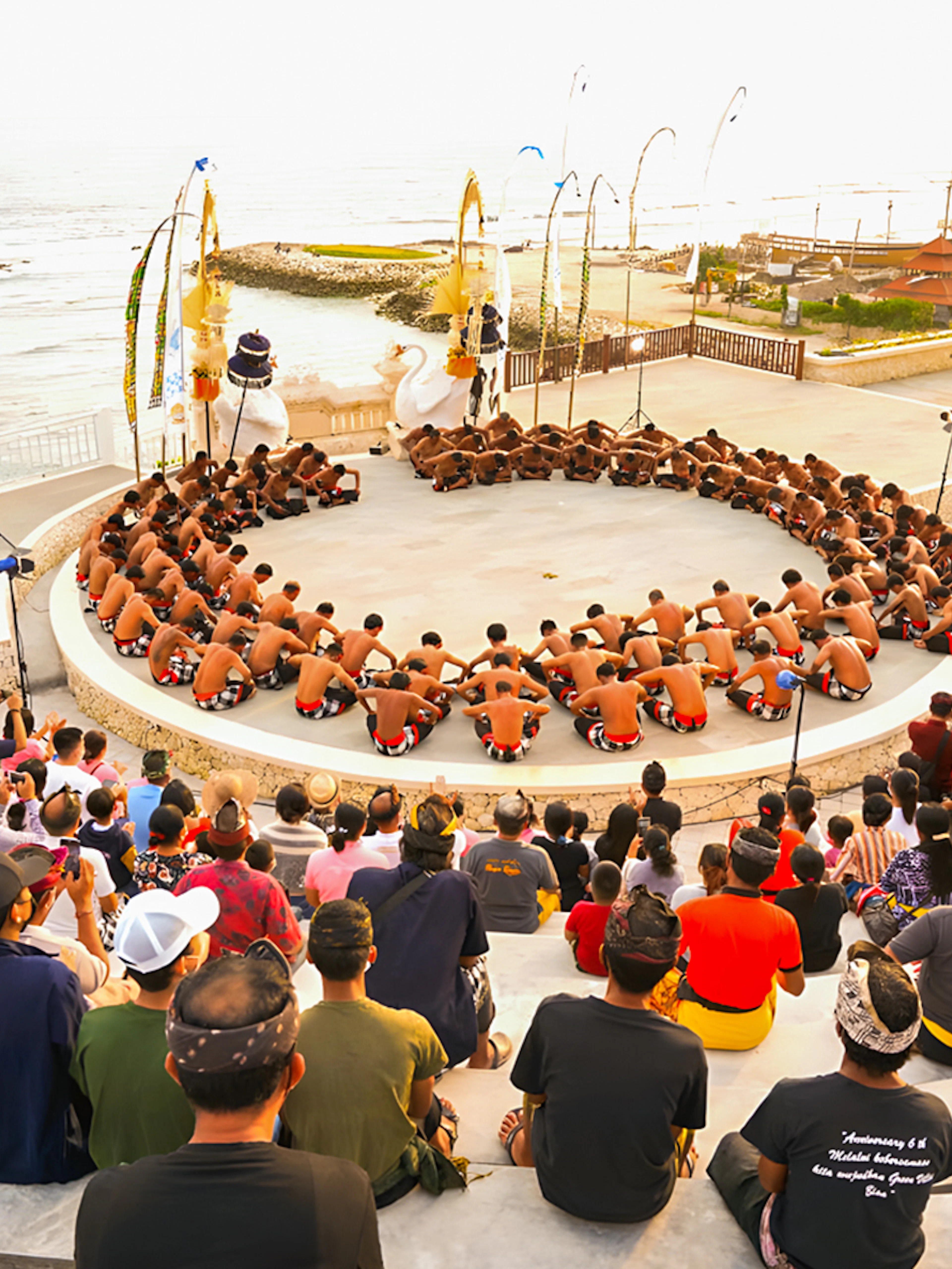 Kecak and Fire Dance performance at Melasti Beach amphitheater with ocean view.