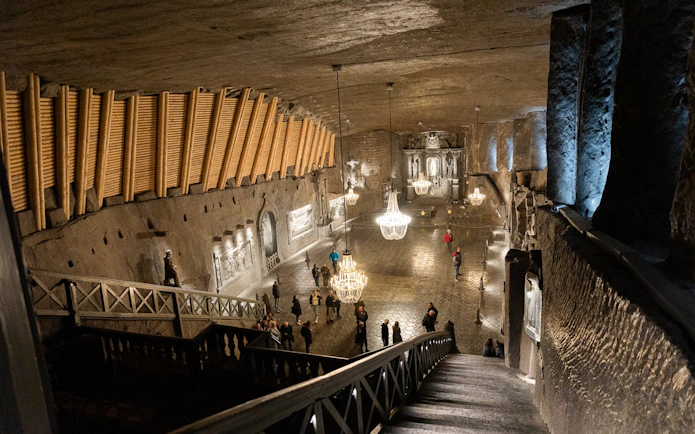 Wieliczka Salt Mine chamber with chandeliers and tourists exploring from Krakow tour.