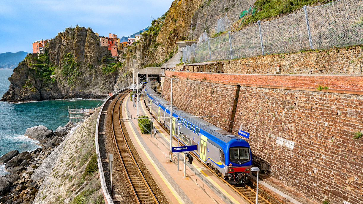 Train at Manarola station with coastal cliffs in Cinque Terre, Italy.