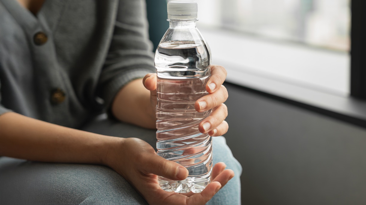 Bottled water held in hands as a welcome drink.