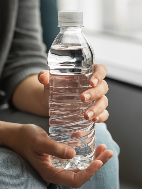 Bottled water held in hands as a welcome drink.