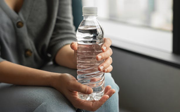 Bottled water held in hands as a welcome drink.