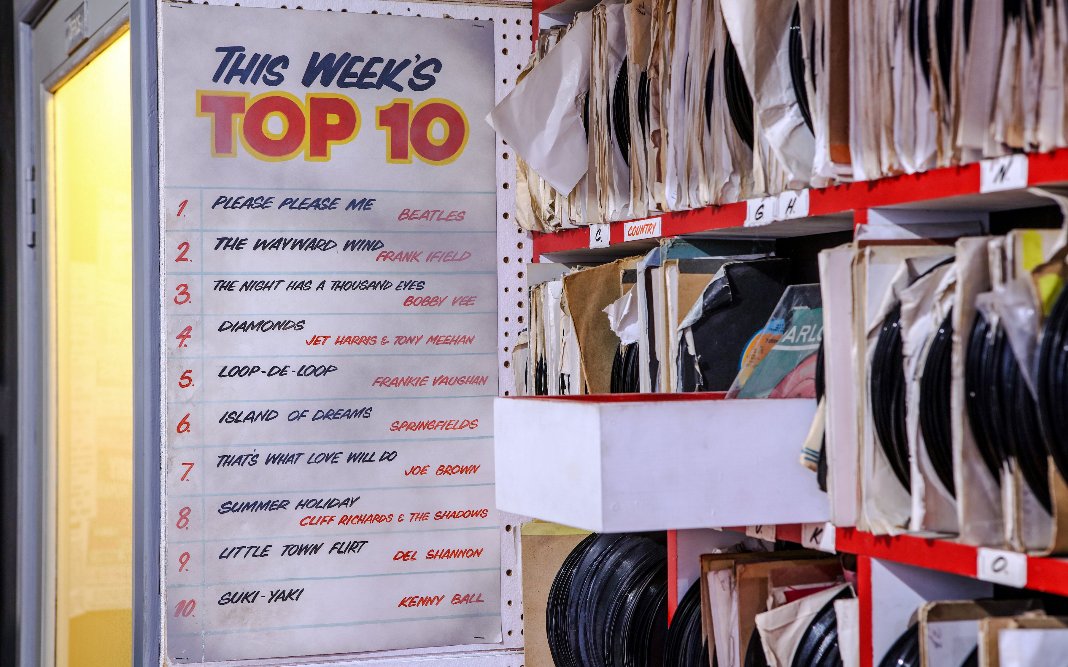 Top 10 chart and vinyl records at The Beatles Story exhibit.