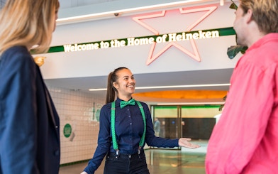 Tourists with guide at Heineken Experience entrance in Amsterdam.