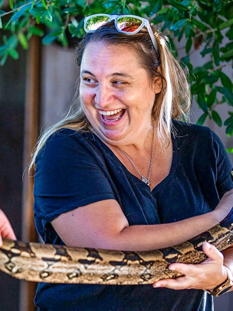 Person holding a large snake at Everglades reptile exhibit.