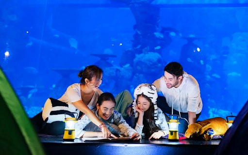 Family enjoying interactive exhibit at Jakarta Aquarium Safari.
