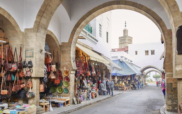 Habbous Market in Casablanca with shops selling leather bags and pottery under stone arches.