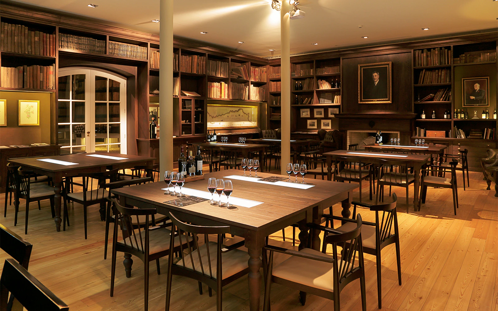 Wine tasting room with tables set for Graham Wine Tasting Experience, featuring glasses and bottles.