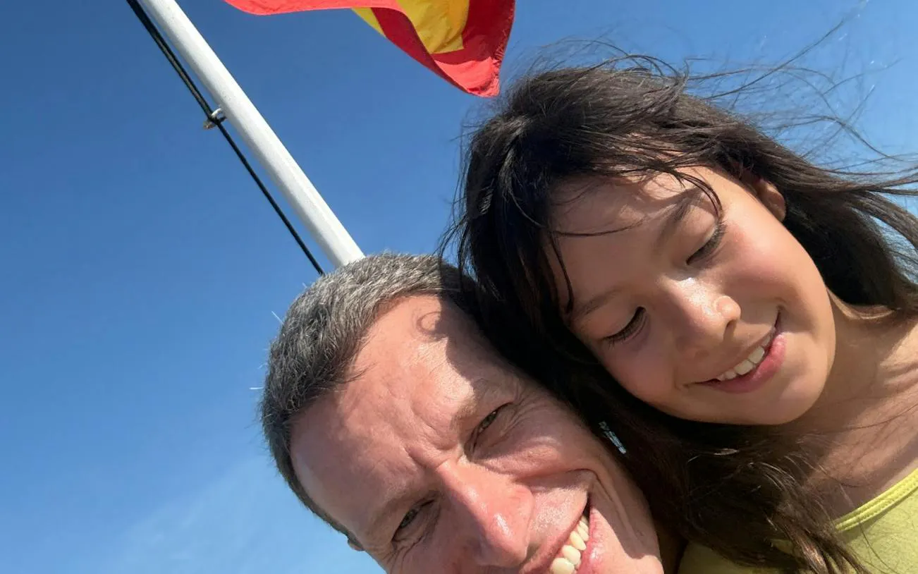 Two people smiling with a flag in Cartagena during the Lost Emerald Mystery tour.