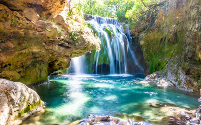 Waterfall cascading into a turquoise pool at Akchour Waterfalls, Chefchaouen, Morocco.