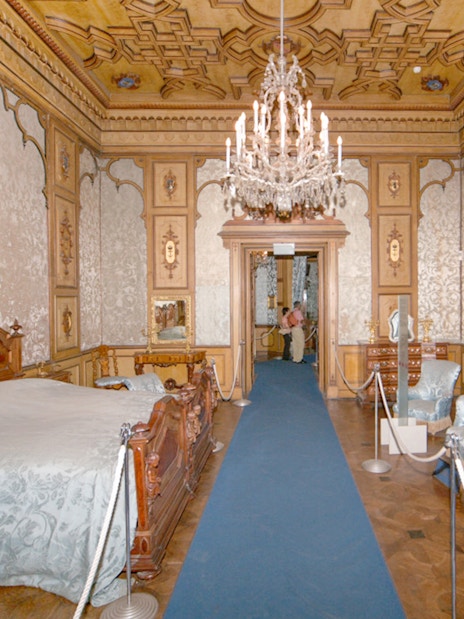 Miramare Castle bedroom with ornate bed and historical furnishings in Trieste, Italy.
